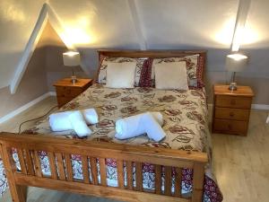 利扎尔德Haelarcher Farmhouse and Helicopter B&B的一间卧室配有一张带两个枕头的木床