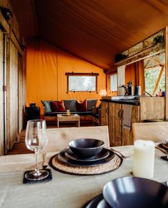 德罗伊特威奇Fibden Farm Glamping - Luxury Safari Lodge的桌上放着碗和一杯葡萄酒