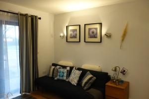 布里斯托Stunning guest house in Frenchay的客厅配有沙发和墙上的两张照片
