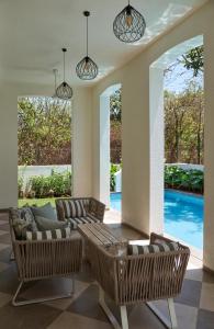 瓦加托LohonoStays Villa Aurelia E的带沙发和椅子的客厅以及游泳池。