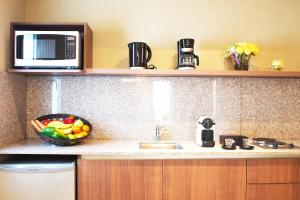 布宜诺斯艾利斯比布鲁斯帕勒莫苏豪公寓的厨房配有水槽、微波炉和一碗水果