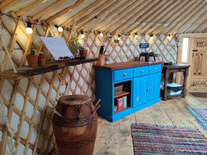 多尔盖罗Pandy Farm Yurt - Panoramic mountain views within Snowdonia's National Park - 4x4 recommended的一间设有蓝色橱柜和圆顶帐篷桌子的房间