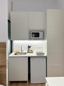 特拉萨SD Habitación céntrica con baño y minicocina的白色的厨房配有微波炉和水槽