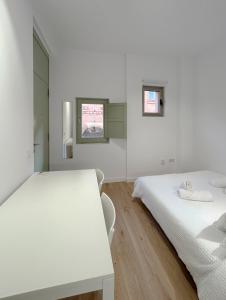 特拉萨SD Habitación céntrica con baño y minicocina的白色的客房配有两张床和一张桌子