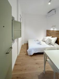 特拉萨SD Habitación céntrica con baño y minicocina的白色卧室配有床和桌子