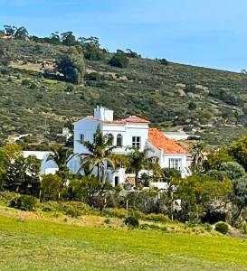 丹吉尔La Finca - 3BR Seaside Villa with Private Pool & BBQ的山坡上一座白色房子,屋顶橙色