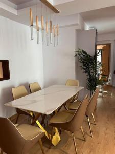 胡鲁马累Luxurious 3-Bedroom in Hulhumalé的一间配备有白色桌椅的用餐室