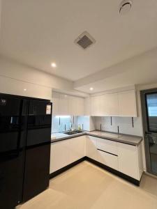 胡鲁马累Luxurious 3-Bedroom in Hulhumalé的厨房配有白色橱柜和黑色冰箱。