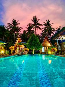 珀尼达岛Mahaloka Valley Nusa Penida的棕榈树度假村的游泳池