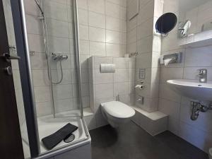 纽伦堡法克曼酒店的带淋浴、卫生间和盥洗盆的浴室