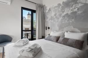沃洛斯Azur Hotel Volos的卧室配有白色床和毛巾