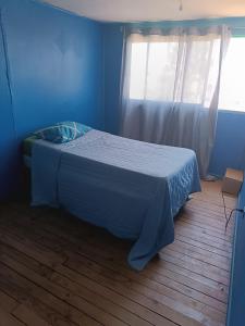 维纳德马Casa yeici的蓝色客房的一张床位,设有窗户