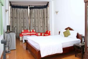河内HOÀNG CƯỜNG HOTEL 15 Nguyễn Thái Học的一间卧室配有两张床和电视。