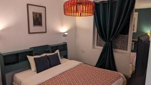 塞纳河畔诺让Aux Écuries Des Pres的一间卧室配有床和黑色窗帘