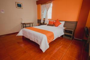 卡哈马卡索尔德贝乐恩卡亚玛尔卡酒店的一间卧室配有一张带橙色墙壁的大床