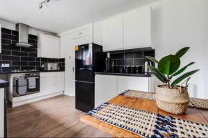 曼彻斯特Newly renovated house near Trafford Centre的厨房配有黑白电器和盆栽植物