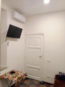 罗马E&A的一间设有白色门的房间和墙上的电视