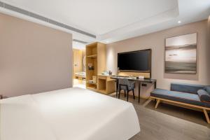 西安西安浐灞会展中心世博园亚朵酒店的一间卧室配有一张床、一张书桌和一台电视。
