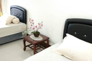 新加拉惹Private Bali Artifac GuestHouse的一间卧室配有一张床和一张桌子,上面有植物