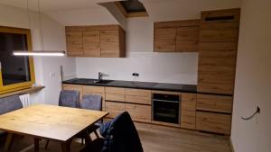 奥蒂塞伊Apartment Aghel的厨房配有木制橱柜和木桌。