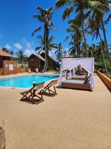 Cabo ConguianeCabana Beach Lodge的度假村旁的游泳池设有帐篷和长椅