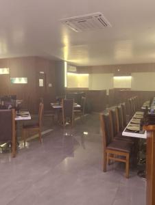 昆达普拉Hotel Samudyatha Inn And Suites的餐厅内带桌椅的用餐室