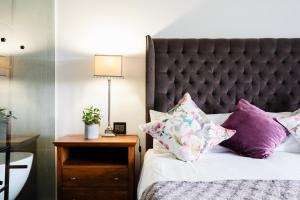 斯泰伦博斯De Zalze Lodge的一间卧室配有一张带紫色枕头的床