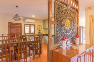 南芭堤雅Bali Haven 3BR PrivatePool Villa的厨房以及带桌椅的用餐室。