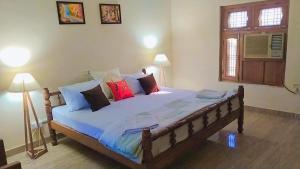 Paliā KalānJungle Heritage的一间卧室配有一张带色彩缤纷枕头的大床
