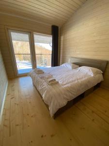 BagnaSoul House的一张大床,位于带两个窗户的房间