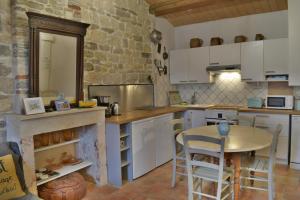 奥雷龙圣但尼La maison du facteur的厨房配有桌子和石墙
