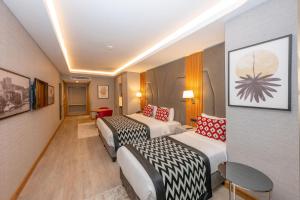 伊斯坦布尔Ramada Encore by Wyndham Istanbul Sisli的酒店客房,设有两张床和一张沙发