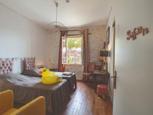 卡斯泰尔诺达里Le Grand Bassin的卧室配有黄色橡皮鸭,坐在床上