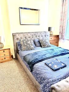 海斯廷斯Relaxing Park View Apartment的卧室内的一张带蓝色棉被和枕头的床