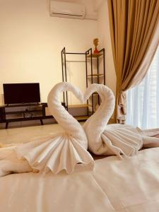 汝来Nilai Youth City Residence的两个天鹅坐在床上