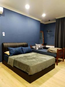 古晋Spacious Home @ Kuching City Ctr的一间卧室设有一张床和蓝色的墙壁