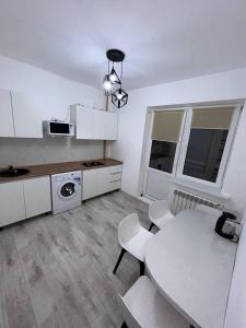 乌拉尔斯克2х комнатная квартира с кодовым замком的白色的厨房配有桌子和桌椅