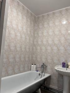 乌拉尔斯克2х комнатная квартира с кодовым замком的带浴缸和盥洗盆的浴室