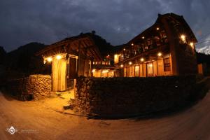 同文Dinh Đá H'Mông - Karsterly Rock Lodge的一座木结构建筑,晚上有灯