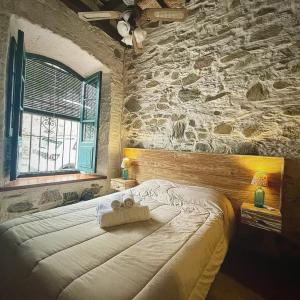 科洛尼亚-德尔萨克拉门托Posada San Gabriel的一间卧室设有一张带石墙的大床