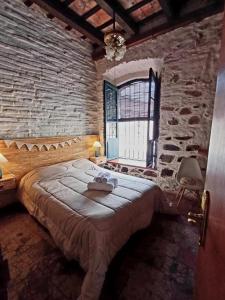 科洛尼亚-德尔萨克拉门托Posada San Gabriel的卧室配有一张石墙内的大床