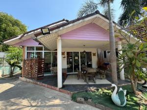 格兰岛Crypto Resort - Koh Larn的一座配有桌椅的粉红色小房子