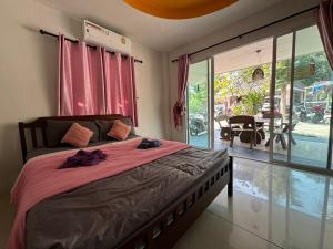 格兰岛Crypto Resort - Koh Larn的一间卧室配有一张带粉色床单的床和大窗户