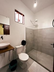 莫雷雷OXE hostel的一间带卫生间和玻璃淋浴间的浴室