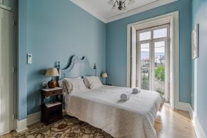卡米尼亚Casa da Avó的蓝色的卧室设有床和窗户