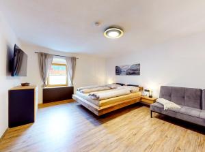 厄茨Ferienhaus Hennewinkl的一间卧室配有一张床和一张沙发