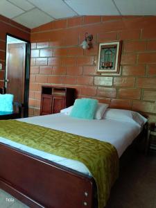 瓜塔佩Cabañas La Honda的卧室设有一张砖墙内的大床