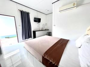 沙敦Rim Suan Resort的一间卧室设有一张床和一个大窗户