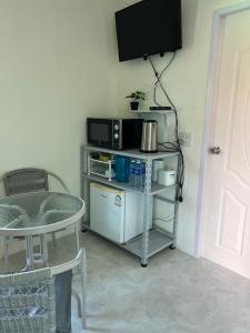 慕斯Pada Guesthouse Khaoyai的客房设有电视和带微波炉的桌子。