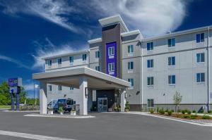 大瀑布城Sleep Inn & Suites Great Falls Airport的一座大型白色建筑,设有停车场